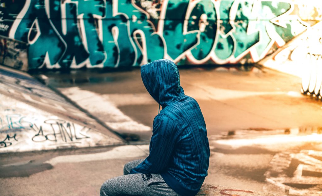 teenager sitting with hood up