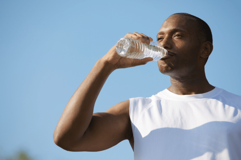 Man drinking water to help metabolize his medication